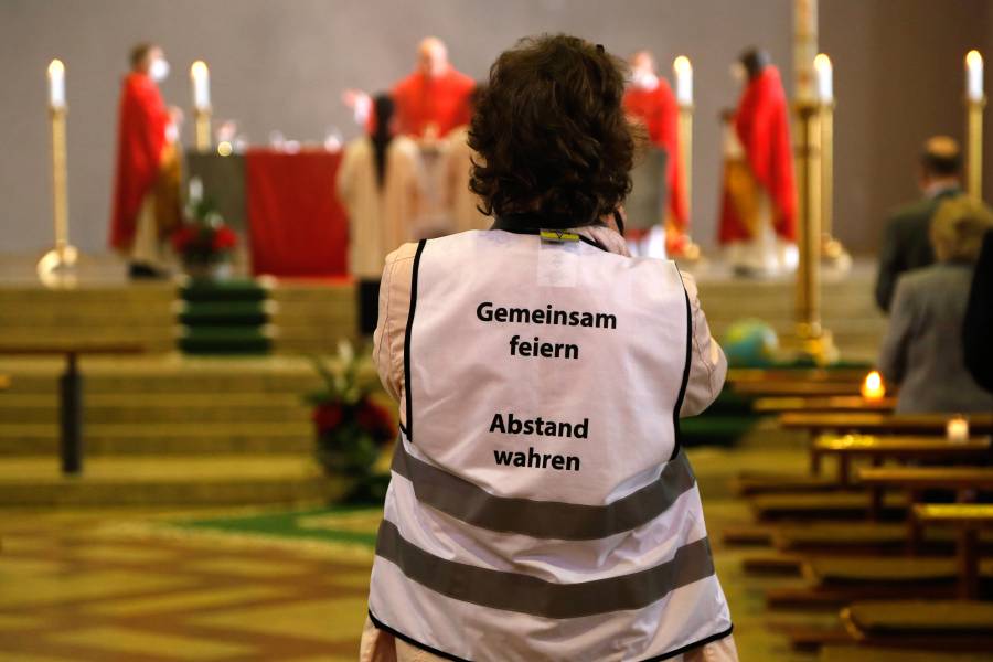 Eine Frau überwacht die Einhaltung der Corona-Regeln während des Gottesdienstes.