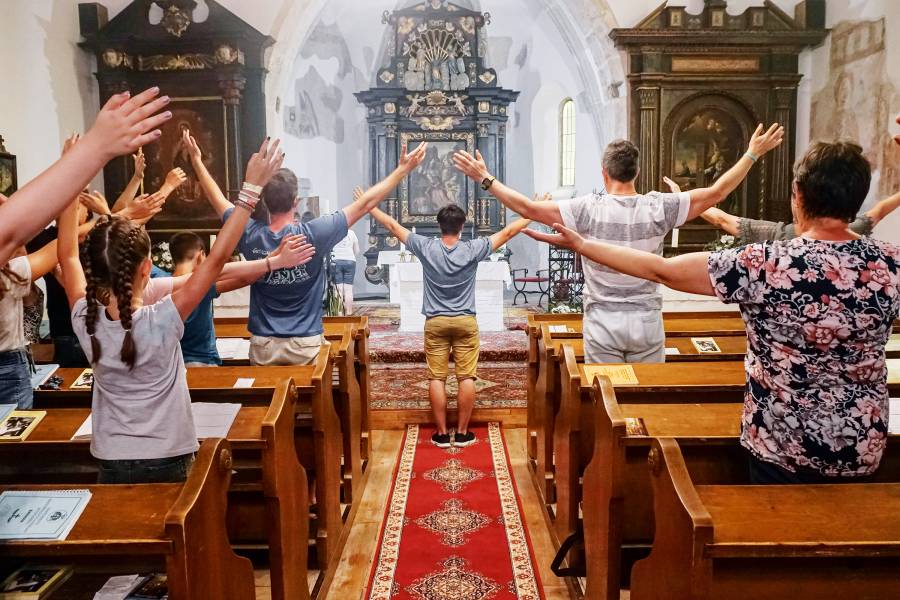 Menschen mit ausgestreckten Armen in einer Kirche in Mátraszőlős