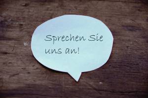 Zettel in Form einer Sprechblase mit dem Text "Sprechen SIe uns an!"