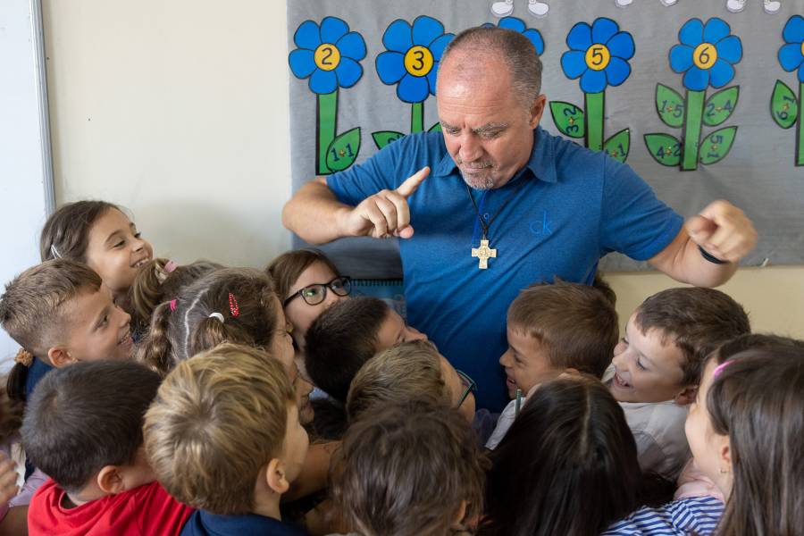 Don Dominik Querimi, der Leiter der Don Bosco Schule in Pristina, mit seinen Schülern.