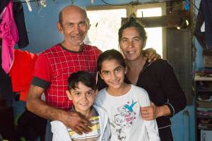 Portrait einer Roma-Familie mit Eltern und zwei Kindern in ihrer Wohnung.