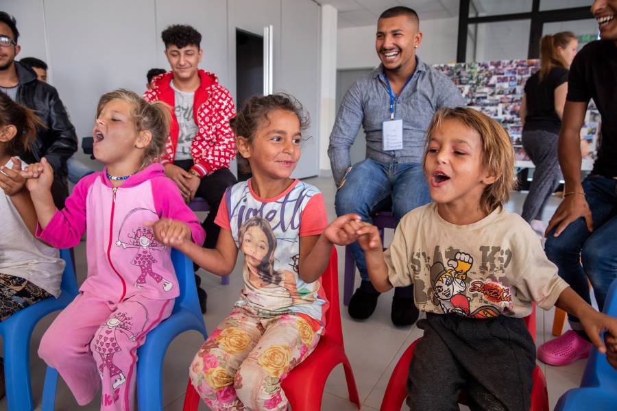 Kinder sitzen ausgelassen in einer Morgenrunde zusammen